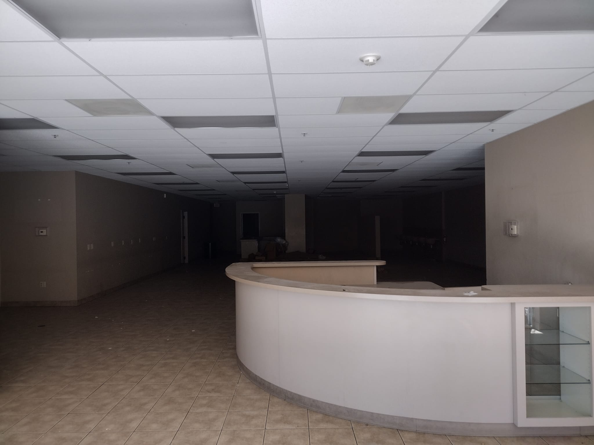 The meme is a screenshot of a completely empty, dark, and abandoned store. The only text in the image is a faint, barely legible caption: "When you finally get to the end of the mall's food court and realize you're still hungry".